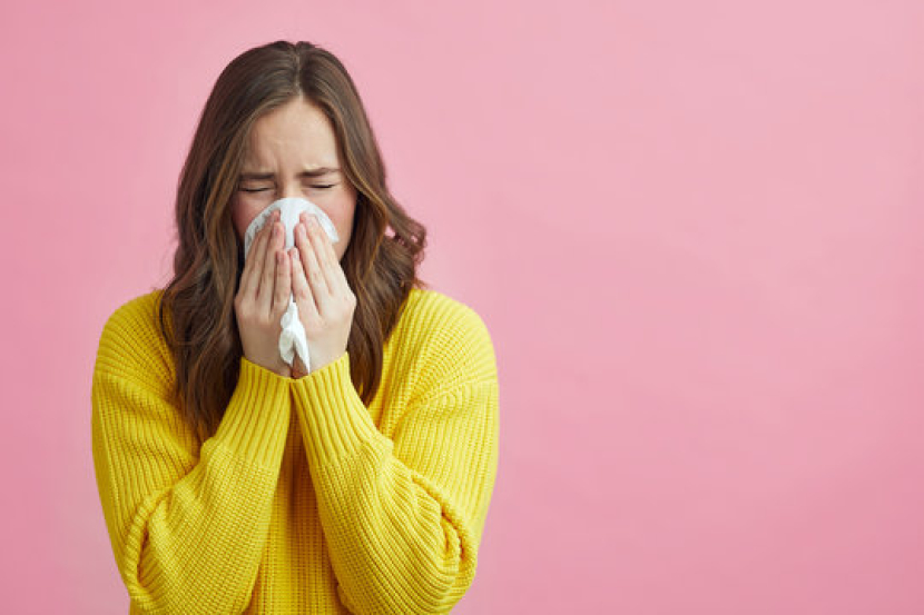 Seorang wanita bersin. Jangan Sekali-kali Menahan Bersin, Ini Bahayanya. Foto: Adobe Stock