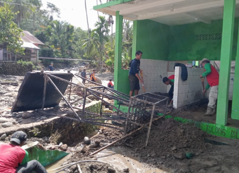 Relawan Posko Jenggala sedang membersihkan lumpur di tempat wudu Mushala Nurul Iman Nagari Limo Koto, Bonjol, Pasaman.