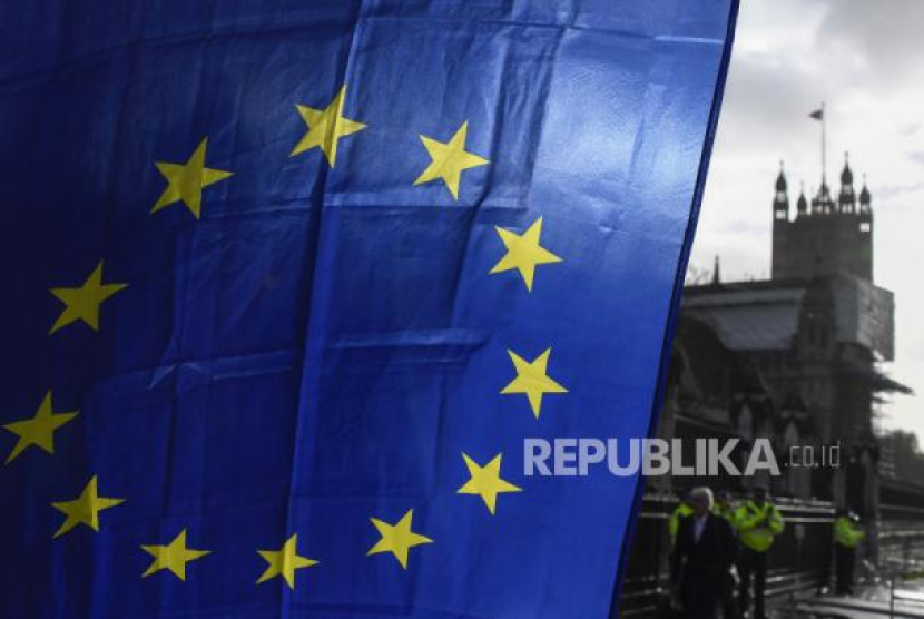 Bendera Uni Eropa dipegang oleh seorang demonstran, dengan latar belakang Menara Victoria, di luar Istana Westminster, di London, Senin, 14 Desember 2020, selama protes saat pembicaraan perdagangan Brexit berlanjut. Foto: AP/Alberto Pezzali