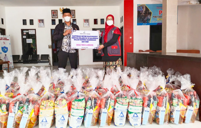 Dewi Nana pengurus PWP bidang Sosial Budaya (kanan) menyerahkan bingkisan dari para istri pekerja Kilang RU VI Balongan kepada Kepala Desa Tegalurung Abdullah. (Istimewa) 