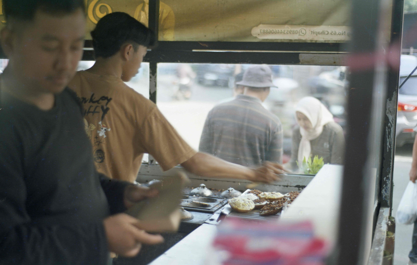 Penjual sedang menyiapkan pesanan surabi. 2012