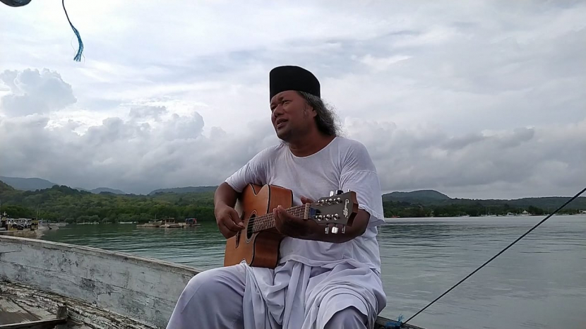 KH Ahmad Muwafiq bermain gitar di atas perahu saar berwisata ke Pulau Noko Gili, Bawean, Rabu (23/2/2022). Foto: Istimewa