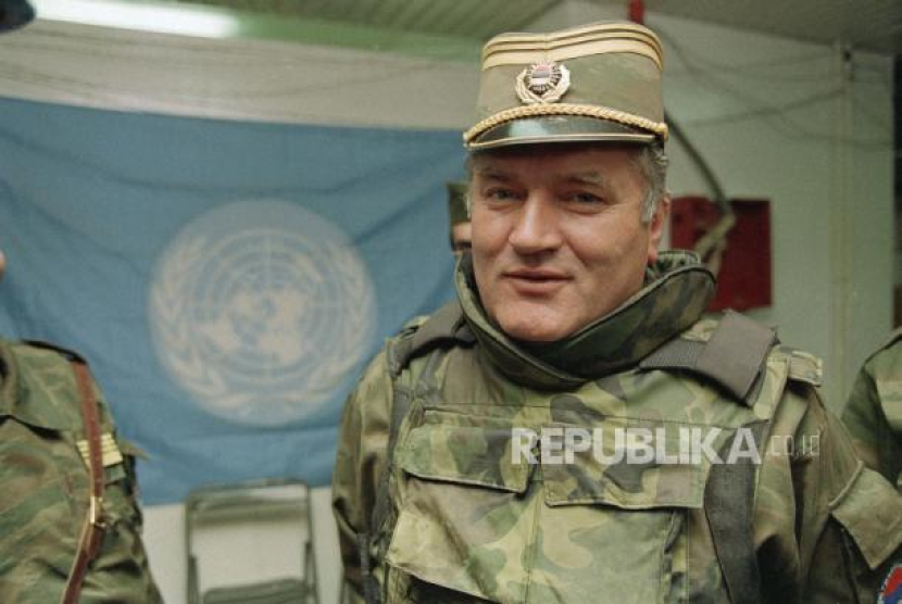 FILE - Dalam file foto 17 Mei 1993 ini, komandan Serbia Bosnia Jenderal Ratko Mladic digambarkan di dekat bendera PBB di Bandara Sarajevo. Hakim-hakim PBB pada Selasa, 8 Juni 2021 memberikan putusan akhir mereka atas vonis terhadap mantan panglima militer Serbia Bosnia Ratko Mladic atas tuduhan genosida, kejahatan perang dan kejahatan terhadap kemanusiaan selama pembantaian etnis Bosnia 1992-1995.