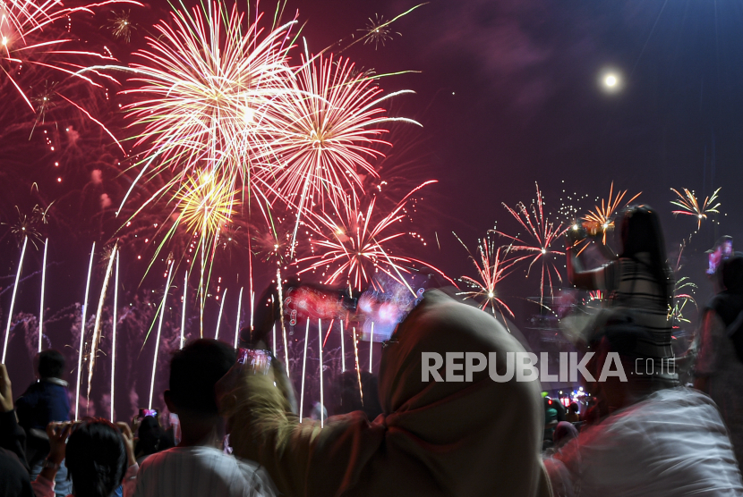 Warga menyaksikan pesta kembang api di Ancol, Jakarta, pada malam pergantian Tahun Baru 2024. Penasarankah kamu sejak kapan kembang api ada dan dari mana warnanya berasal? (Dok. ANTARA FOTO/Muhammad Adimaja)