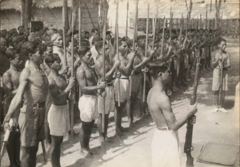 Pemuda Indonesia mengenakan celana pendek berdiri dalam formasi dengan menggemgam bambu runcing. Selama masa perang kemerdekaan melawan Belanda Pemuda dari Laskar Bambu Runcing siap dengan tombak untuk menghadapi Belanda pada tahun 1946 di Indonesia saat ini. Sedikitnya 100.000 orang Indonesia tewas sebagai akibat langsung dari perang kemerdekaan [File: ANRI/IPPHOS/Handout via Reuters]