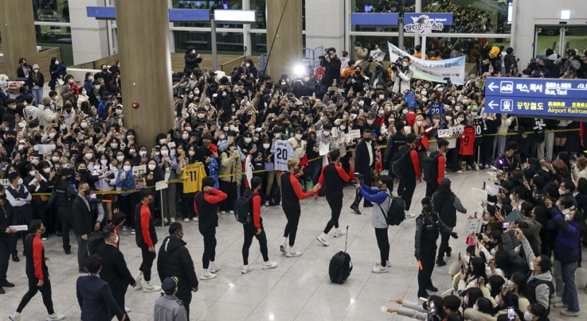 Anggota tim sepak bola nasional disambut oleh kerumunan besar pendukung di Bandara Internasional Incheon, Rabu. Foto: <a href=