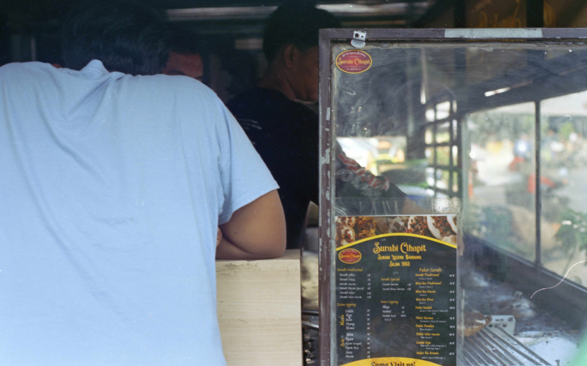 Pembeli sedang melihat langsung proses mamasak surabi. 2019