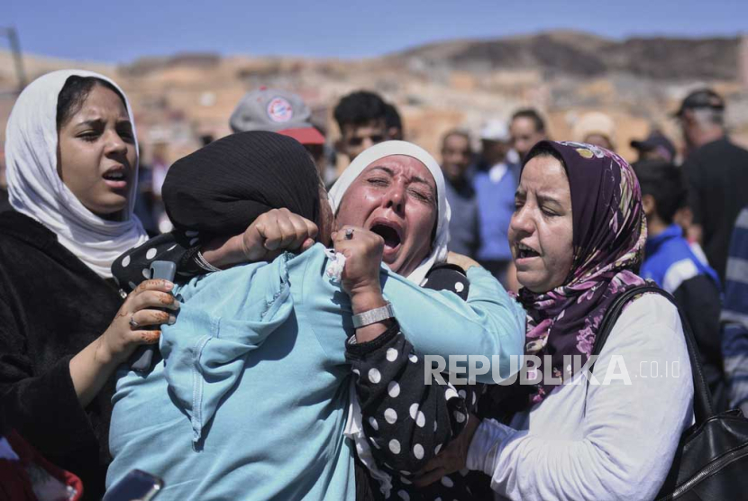 Para wanita menangis saat mereka berduka atas para korban gempa bumi di Moulay Brahim di provinsi Al Haouz, Maroko, Ahad (10/9/2023). (Fernando Sanchez/Europa Press via AP/Republika.co.id)