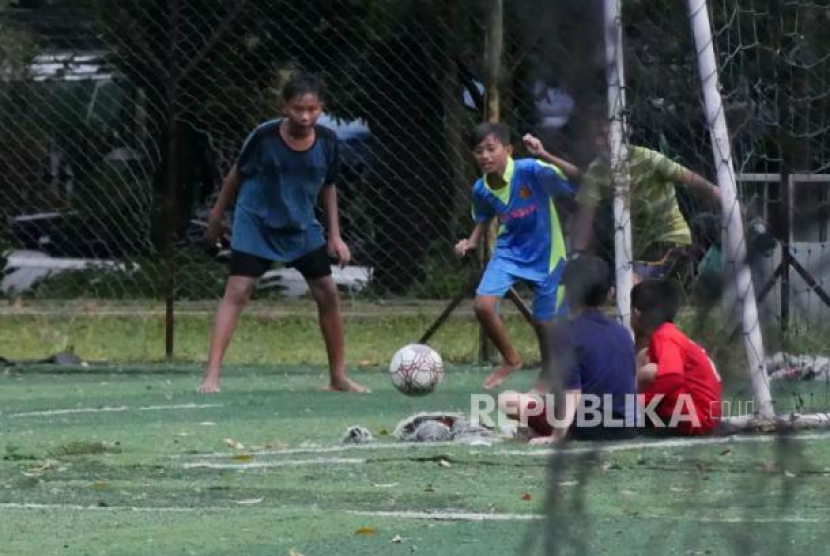 Sejumlah anak bermain bola saat hujan di Taman Persib di Jalan Supratman, Kota Bandung, Jumat (20/1/2023). Foto: Republika/Edi Yusuf