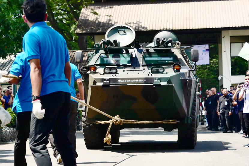 Dari balik kemudi, seorang petugas menjaga kemudi agar Panser Anoa 6x6 tidak berbelok saat ditarik perserta lomba Tarik Panser.