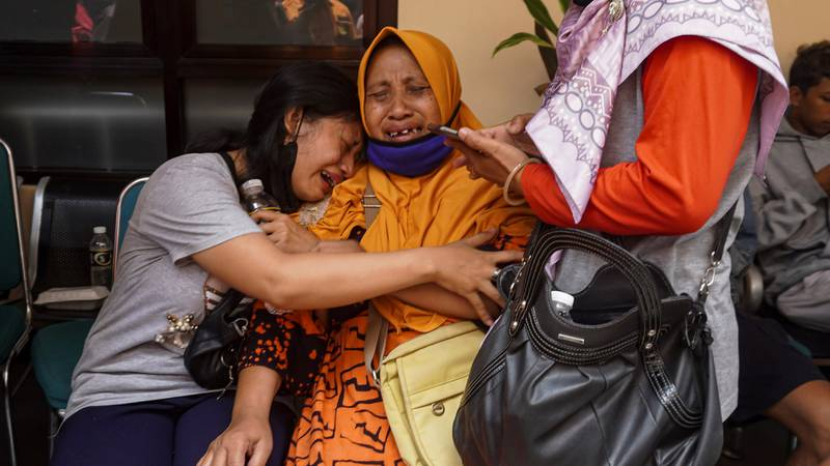 Perempuan menangis setelah menerima konfirmasi bahwa anggota keluarga mereka termasuk di antara mereka yang tewas dalam kerusuhan sepak bola, di sebuah rumah sakit di Malang, Jawa Timur, Indonesia. (Sumber: Associated Press)