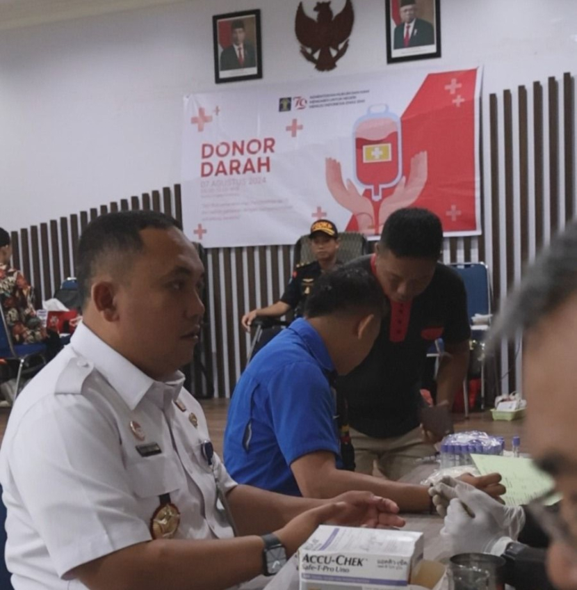 Kepala Kantor Imigrasi Kelas II TPI Entikong, Henry Dermawan Simatupang, menjadi salah satu pendonor dalam kegiatan Donor Darah Sambut HUT Ke-79 RI dan Hari Pengayoman Ke-79 di Senggau, Kalimantan Barat, Rabu (7/8/2024). (Foto: Imigrasi Entikong)