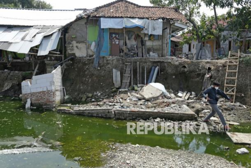 Warga melihat kondisi rumah yang rusak akibat longsor di Desa Kertasmaya, Indramayu,. Pergerakan tanah yang terjadi di bantaran<a href=