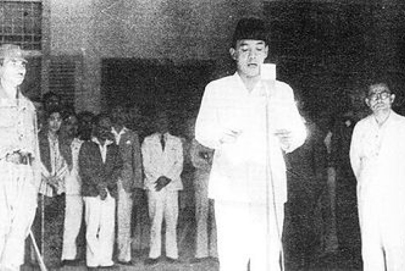 Sukarno didampingi Hatta membacakan Proklamasi Kemerdekaan di depan mikrofon hasil rakitan Gunawan. Malam harinya, Sukarno membacakan ulang proklamasi di depan mikrofon pemancar radio gelap setelah para mahasiswa gagal menyiarkannya melalui radio Jepang (foto: dokumentasi perpusnas).