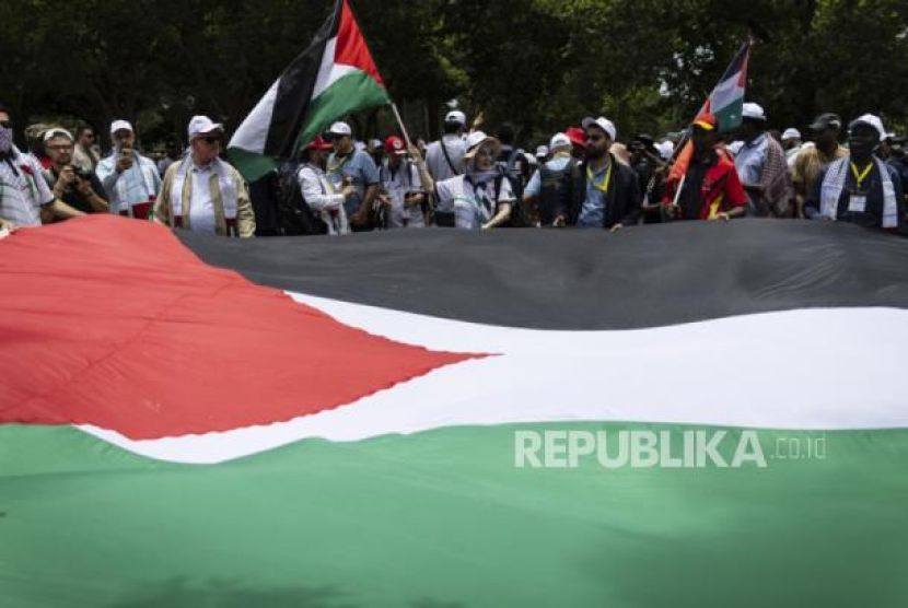 Aksi protes yang dilakukan massa sambil membentangkan bendera Palestina sebagai bentuk solidaritas di Pretoria, Afrika Selatan (5/12/2023) (dok. EPA-EFE/KIM LUDBROOK)