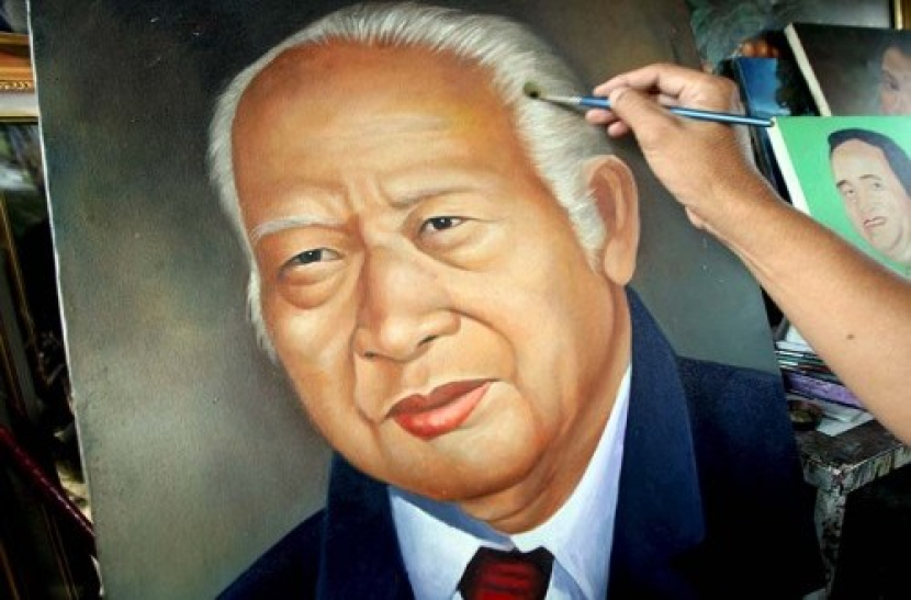 Seorang pelukis melukis wajah Presiden RI ke-2 Soeharto. Foto: EPA/Weda