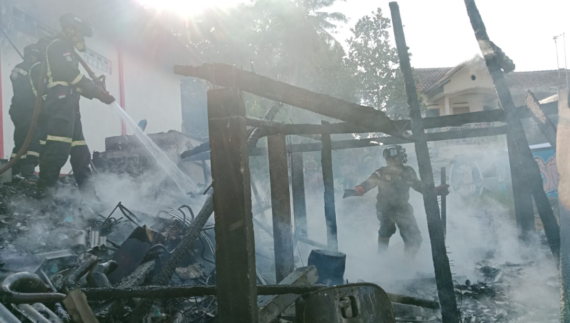 Petugas pemadam kebakaran sedang memadamkan api yang membakar sebuah bengkel di Dusun Pon, Desa Caracas, Kecamatan Cilimus, Kabupaten Kuningan. (Dok Damkar Kuningan)
