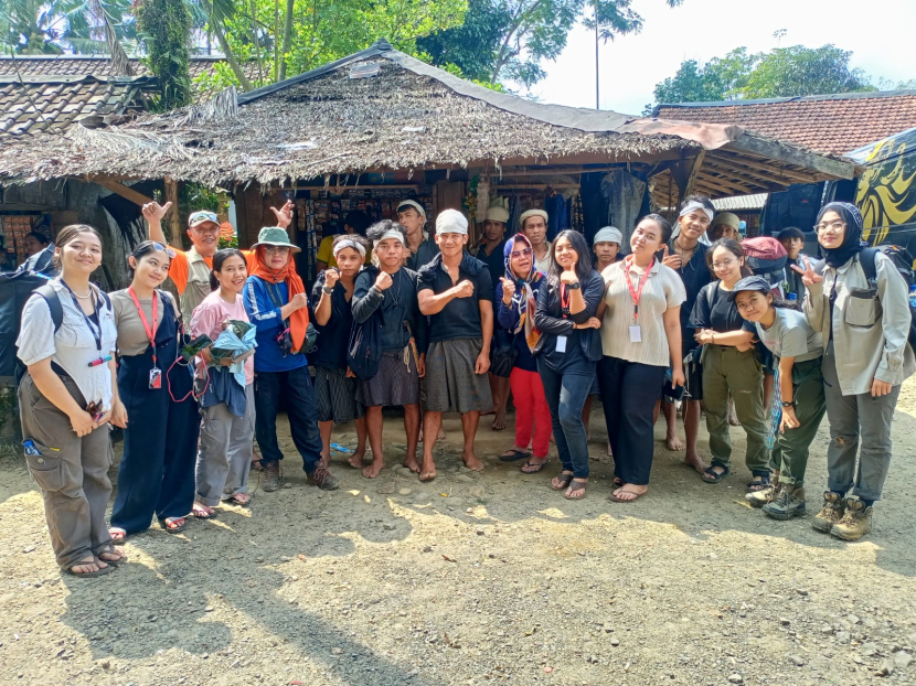 Sapri (tengah dengan ikat kepala putih tangan mengepal di dada) diajak foto bersama oleh rombongan perempuan yang berkunjung ke Baduy dalam.