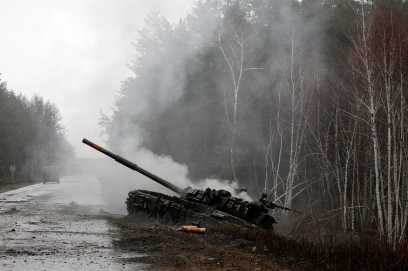 Asap mengepul dari tank Rusia yang dihancurkan oleh pasukan Ukraina di sisi jalan di Luhansk pada 26 Februari 2022.