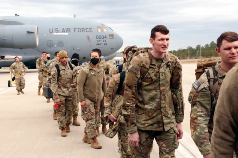 Prajurit Angkatan Darat AS dari Divisi Lintas Udara ke-18 menaiki pesawat C-17 saat mereka dikerahkan ke Eropa dari Fort Bragg.