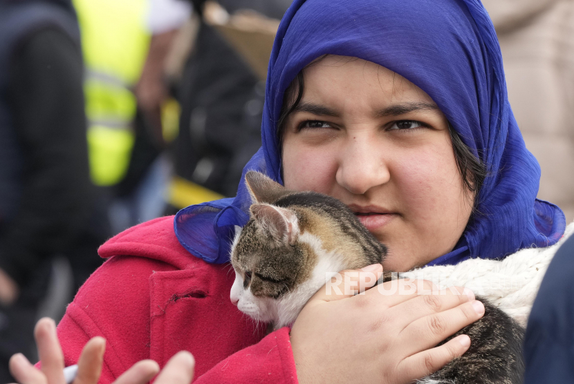 Seorang pengungsi dari Ukraina memegang kucingnya di perbatasan Korczowa, Polandia, Ahad, 27 Februari 2022. Duh Meng, Gara-Gara Invasi ke Ukraina, Kucing Rusia Dilarang Ikut Kompetisi Internasional. Foto: AP/Czarek Sokolowski 