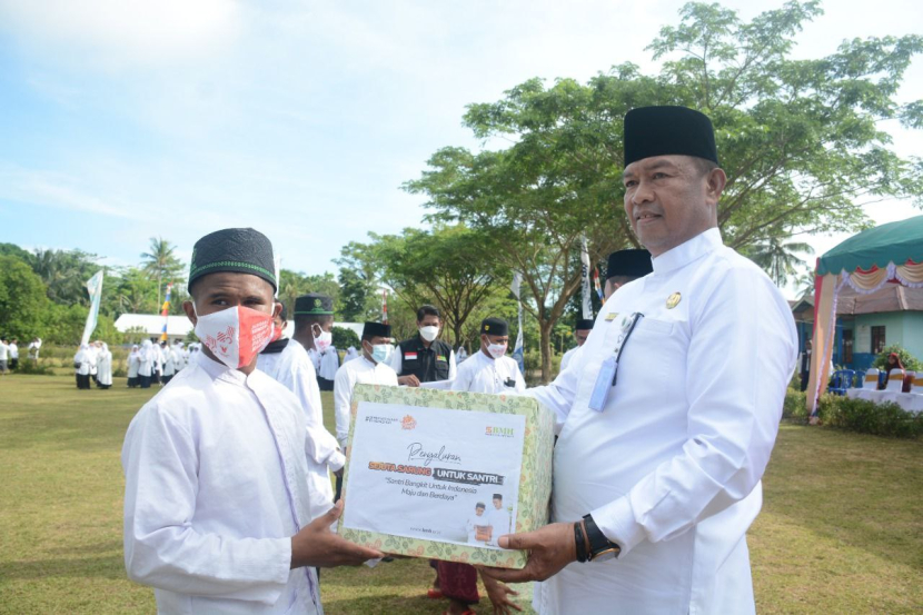 Kepala Kantor Wilayah Kementerian Agama Provinsi Maluku H Yamin SAg MPdI menyerahkan sarung untuk santri secara simbolik.