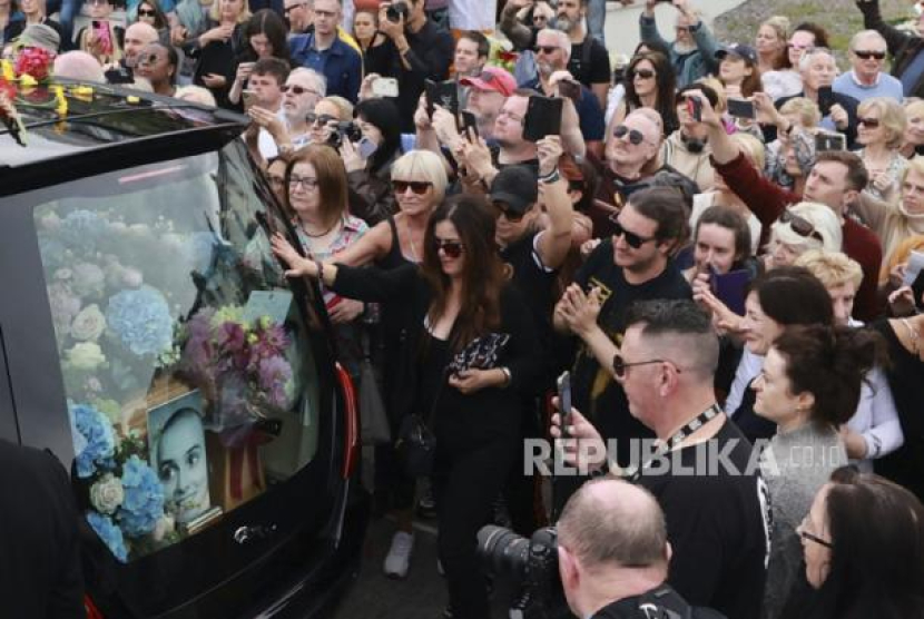 Ribuan penggemar Sinead O'Connor atau Shuhada Sadaqat berbaris di jalan-jalan saat menyaksikan proses pemakamannya di County Wicklow, Irlandia, Selasa (8/8/2023). Foto: Liam McBurney/PA via AP