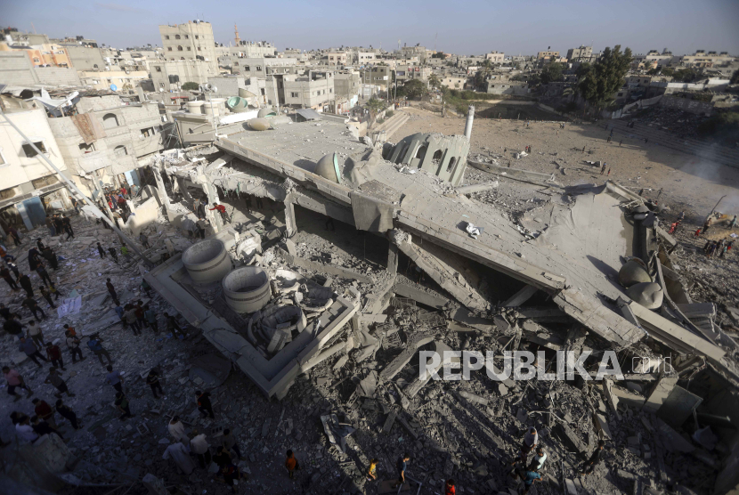 Warga Palestina memeriksa kerusakan masjid yang hancur akibat serangan udara Israel di kamp pengungsi Khan Younis, Jalur Gaza selatan, Rabu, (8/11/2023). (AP Photo/Mohammed Dahman)