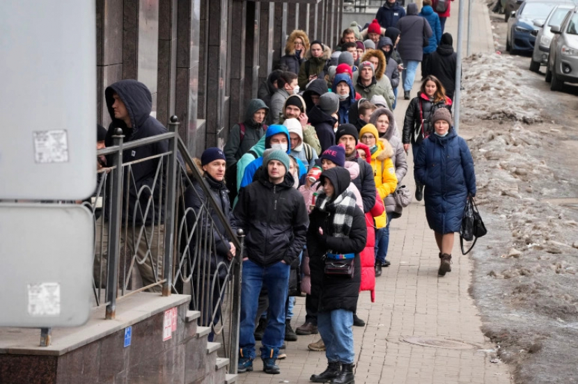 Orang-orang mengantre untuk menarik dolar AS dan euro dari ATM di St Petersburg, Rusia pada 25 Februari 2022 [AP/Dmitri Lovetsky]