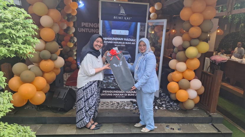 Simbolis penyerahan hadiah dari PLT Marketing Manager Bumi Aki Group, Dwianti Salma, (kiri) kepada pihak notaris. (Foto: Bumi Aki Group)