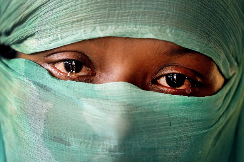 Seorang perempuan Rohingnya berinisial F., 22 dengan mengenakan penutup muka berderai air matanya ketika mengisahkan perkosaan terhadapnya atas permintaan seorang oknum tentara Mynmar. Kebrutalan itu terjadi pada bulan Juni dan diulangi kembali pada bulan September. Perempuan ini berhasil di foto ketika tinggal di kamp pengungsian yang berada di Kutupalong, Bangladesh pada 22 November 2017. (foto: AP)