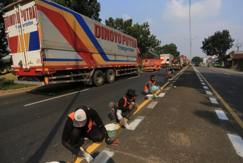 Sejumlah pekerja menyelesaikan pengecatan marka jalan di jalur pantura Widasari, Indramayu, Jawa Barat, Sabtu (16/4/2022). Pengecatan marka jalan tersebut untuk meningkatkan keselamatan dan kenyamanan pemudik yang akan melintas saat mudik Lebaran 2022. - (ANTARA/Dedhez Anggara)