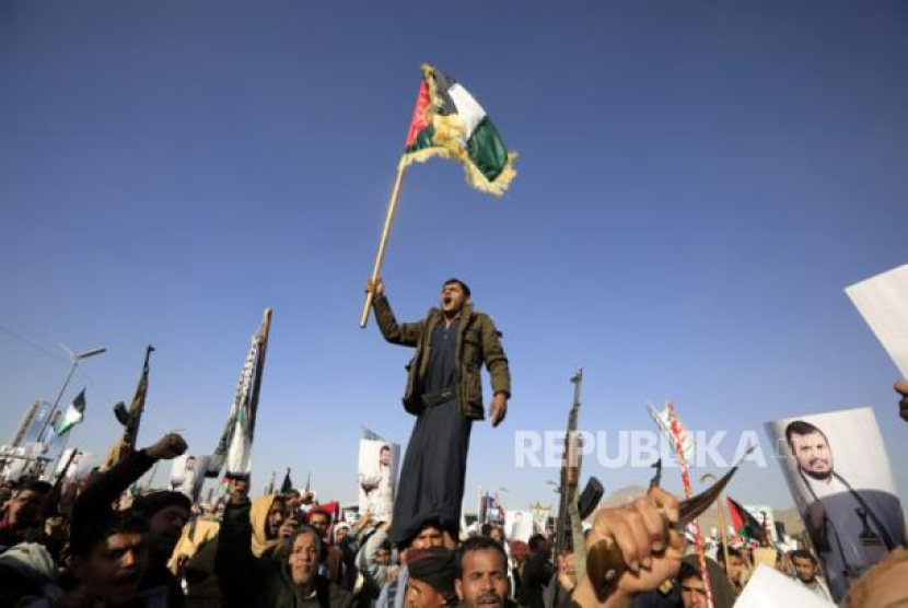 Seseorang meneriakkan slogan-slogan sambil mengibarkan bendera Palestina dalam protes terhadap operasi multinasional untuk melindungi pelayaran Laut Merah menyusul serangan udara AS dan Inggris terhadap situs militer Houthi, di Yaman (dok. APA-EFE/YAHYA ARHAB)