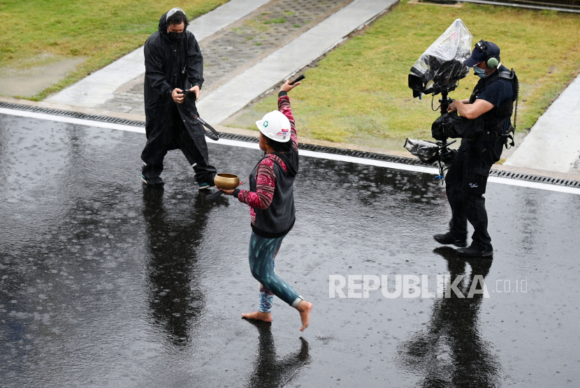 Pawang hujan Rara Isti Wulandari (tengah) melakukan ritual saat hujan mengguyur Pertamina Mandalika International Street Circuit, Lombok Tengah, NTB, Ahad (20/3/2022). Start balapan MotoGP seri Pertamina Grand Prix of Indonesia sempat diundur dari jadwal semula karena cuaca buruk. (FOTO : ANTARA/Andika Wahyu)