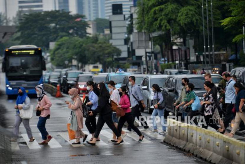 Pekerja melintas di pelican crossing di kawasan Perkantoran Sudirman, Jakarta, Rabu (26/4/2023). Foto: Republika/Thoudy Badai