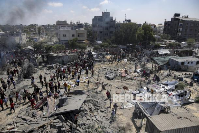 Warga Palestina memeriksa kerusakan di lokasi yang terkena pemboman di Khan Younis, Jalur Gaza selatan. (Dok. Republika/Ap Photo)