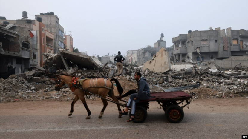 Seorang pria mengendarai kereta kuda di sepanjang jalan yang dilanda pemboman Israel di Rafah di Jalur Gaza selatan pada 9 Februari 2024.