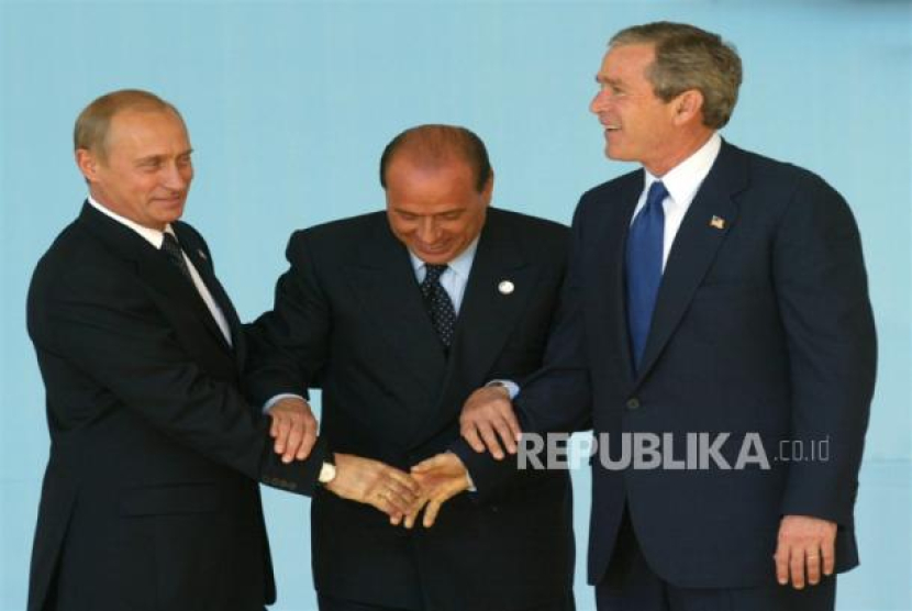 Perdana Menteri Italian Silvio Berlusconi (tengah) dalam gestur menghentikan jabat tangan Presideb Rusia Vladimir Putin (kiri) dan Presiden AS George W Bush pada pertemuan Rusia-NATO di Roma, Italia, 28 Mei 2002. Sumber: EPA-EFE/SERGEI CHIRIKOV. file (Republika.co.id).
