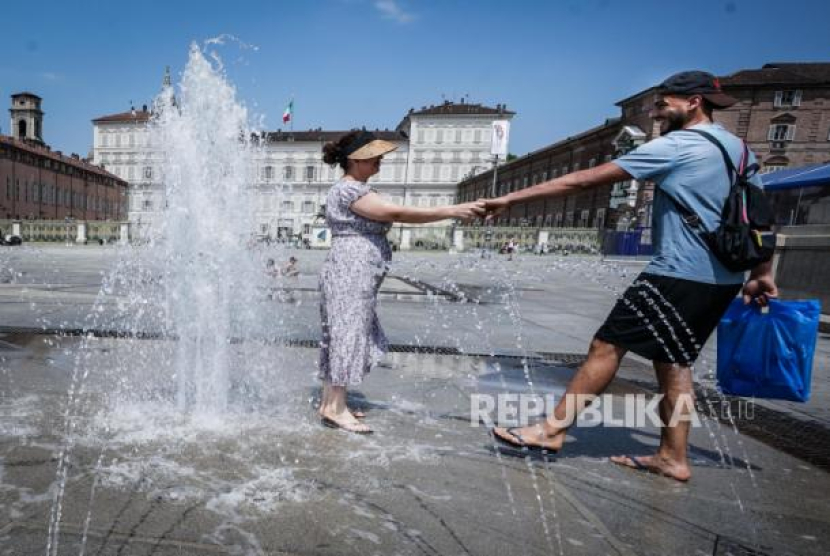 Sejumlah orang mendinginkan diri di air mancur Piazza Castello di tengah suhu tinggi di Turin, Italia, Selasa (11/7/2023) waktu setempat. Eropa Selatan Membara, Suhu Panas Tembus 44 Derajat Celsius. Foto: EPA-EFE/Tino Romano