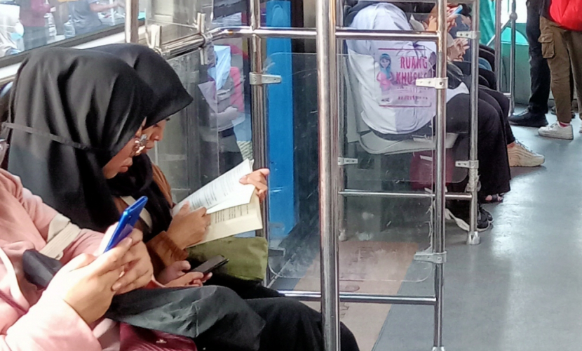 Seorang penumpang sedang asyik membaca buku di Transjakarta. Bang lawi selalu senang melihat ada orang yang mau membaca buku di angkutan publik.