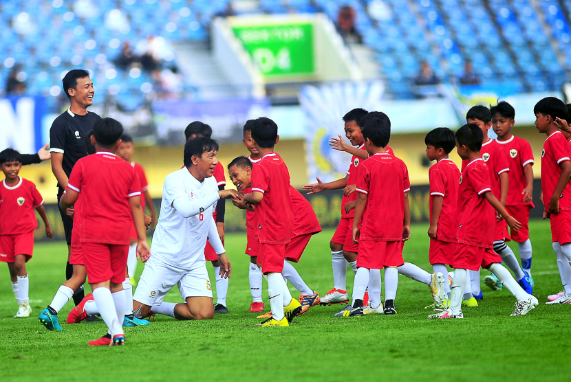 Mantan bek Persib Bandung Robby Darwis dikerubuti puluhan siswa SSB yang sungkem karena menjatuhkan legenda Persib ini pada laga funsoccer jelang pembukaan Turnamen Piala Presiden 2024 di Stadion Si Jalak Harupat, Kabupaten Bandung, Jumat (19/7/2024). (FOTO: YOGI ARDHI/REPUBLIKA NETWORK) Nikon D3, Nikkor 300/2.8 ED MF.