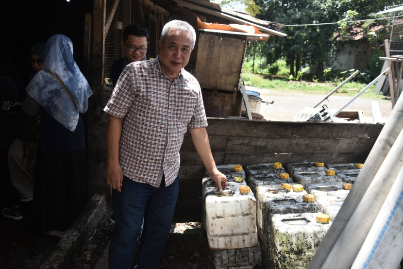 Dosen Ketua Kelompok Keahlian Informatika ITB Kridanto Surendro berdiri di samping deretan  jerrycan berisi limbah minyak jelantah di salah satu sentra produksi kerupuk kulit di Kabupaten Garut.