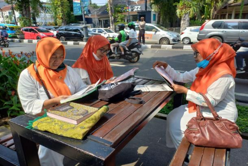 Masyarakat yang terdiri dari emak-emak, bapak-bapak serta pemuda dan pemudi di Kota Bandung membaca<a href=