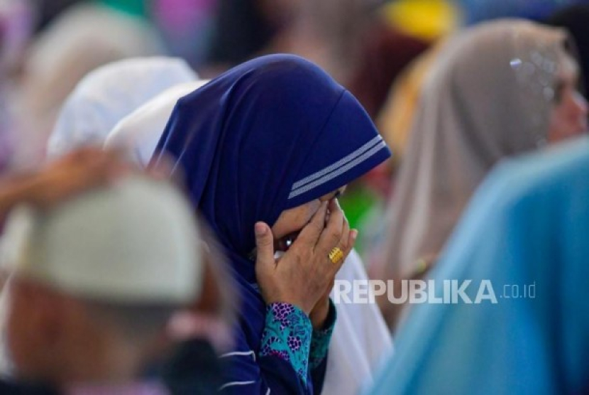 Warga mengusap mukanya saat dzikir dan doa bersama di Masjid Agung Natuna, Kepulauan Riau, Kamis (6/2/2020). Foto: Antara Foto/M Risyal Hidayat