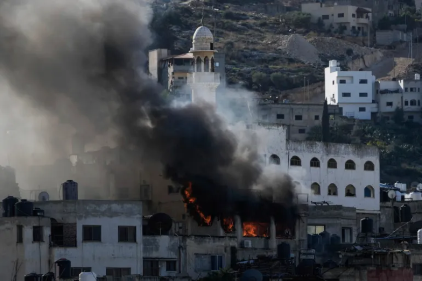 Api dan asap membubung selama operasi tentara Israel di Jenin, Tepi Barat [Fotio: Majdi Mohammed/AP/Aljazeera]