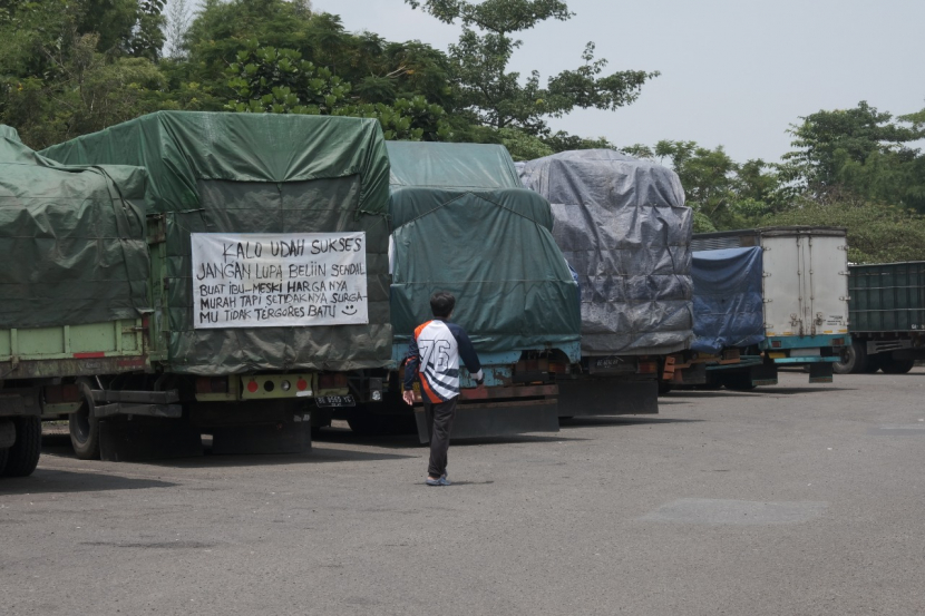 Seorang pengunjung berjalan di deretan truk yang terparkir di rest area KM 130 A Titirah Kahirupan, Sabtu (19/3/2022). (Lilis Sri Handayani)