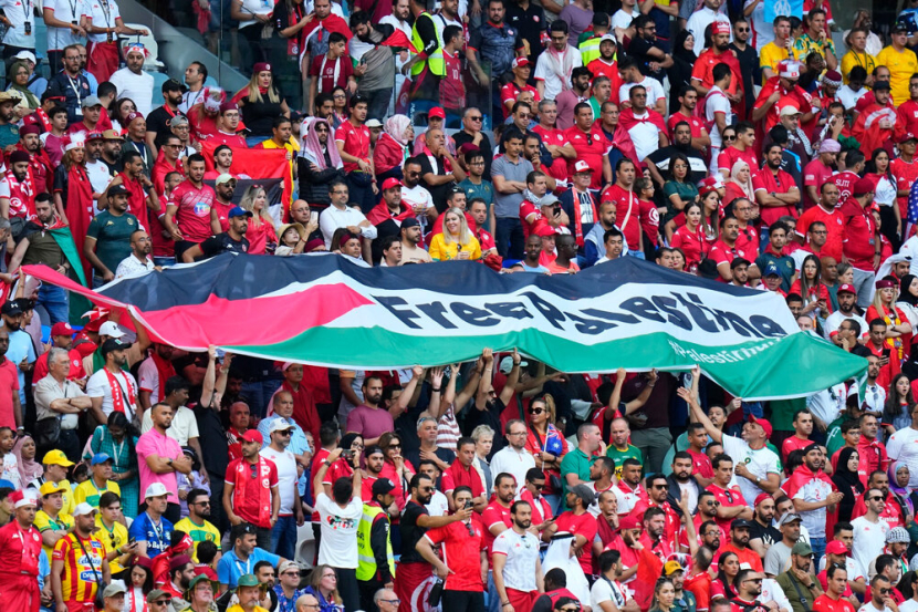 Bendera Palestina berkibaran di tribun penonton sepanjang pertandingan sepakbola final putaran pilada dunia di Qatar.
