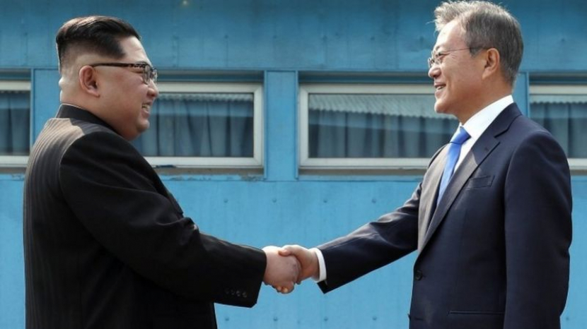 Pemimpin Korea Utara, Kim Jong-un dan Presiden Korea Selatan, Moon Jae-in berjabat tangan di salah satu acara pertemuan. (dok. BBC.co.uk)