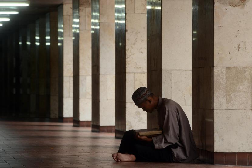 Keterangan: Seseorang sedang membaca Al-Quran di masjid