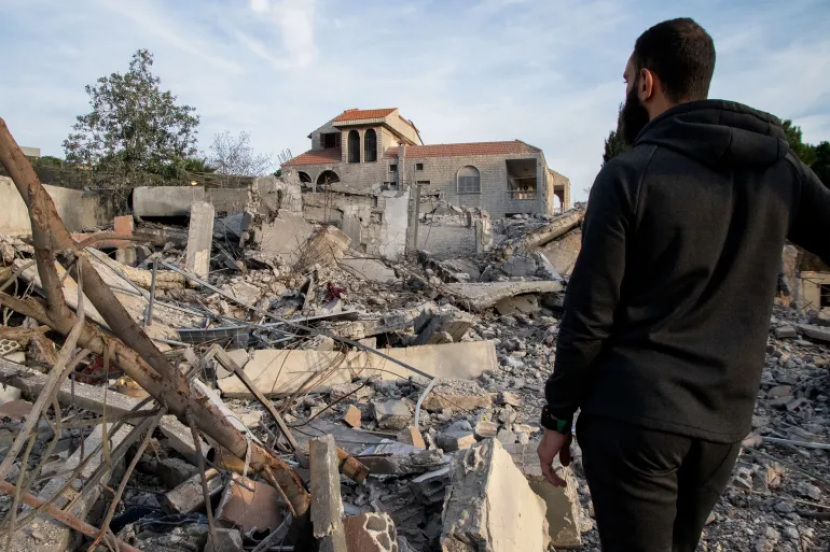 Seorang pria memeriksa bangunan yang hancur pada 8 Januari 2024, setelah serangan udara Israel di desa Kfar Kila di selatan, Lebanon.